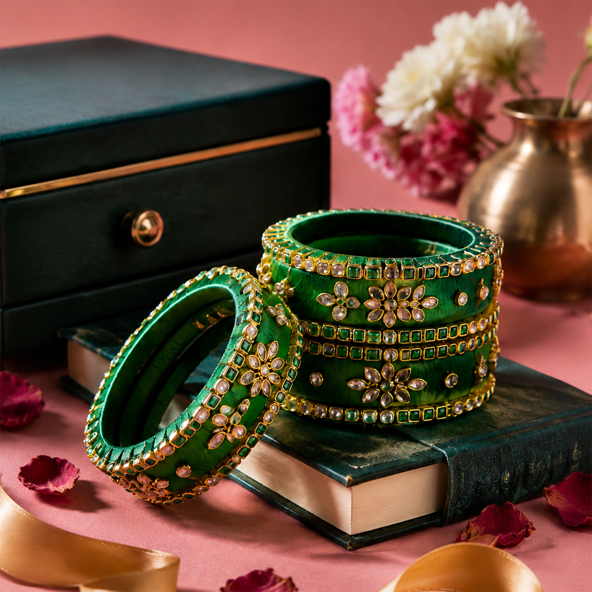 Emerald green silk thread bangles with gold floral detailing in a premium display
