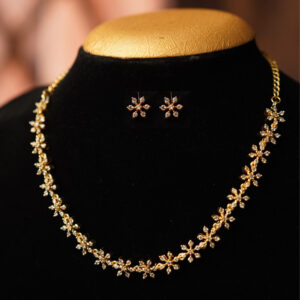Golden Floral Charm Necklace Set on Jewellery Bust