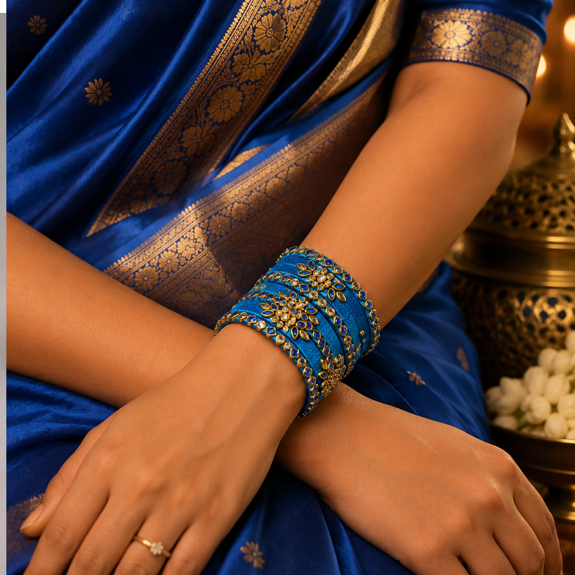 Sky blue and gold floral silk thread bangles worn with a blue saree